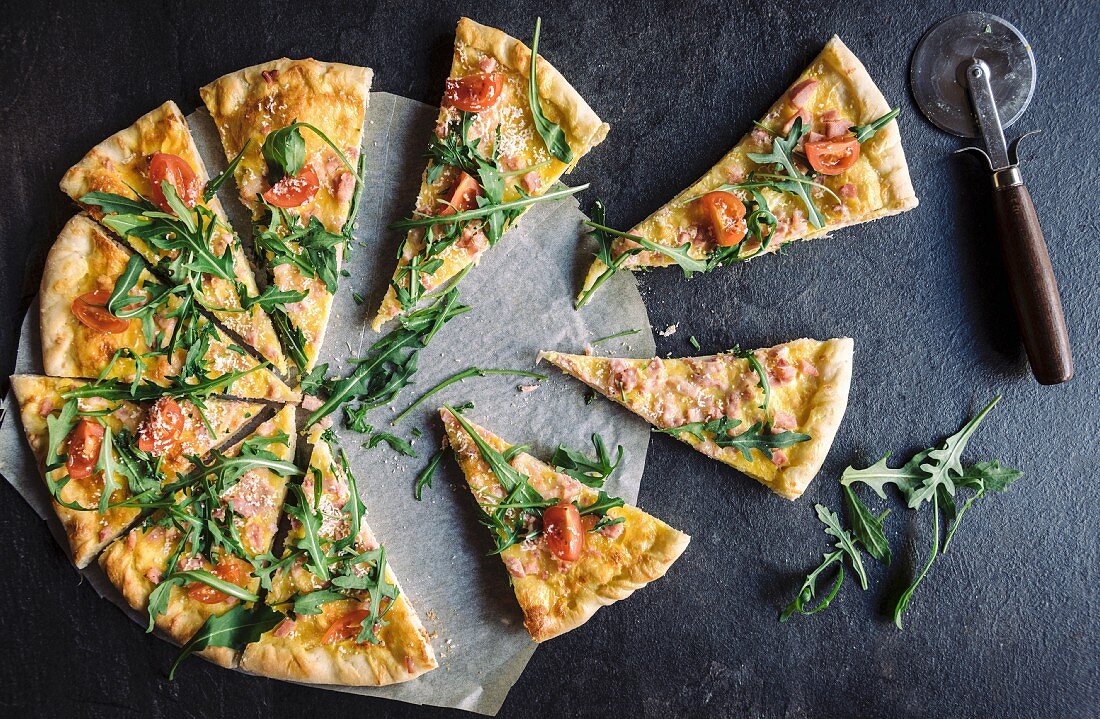 A sliced vegetarian pizza with cheese and rocket