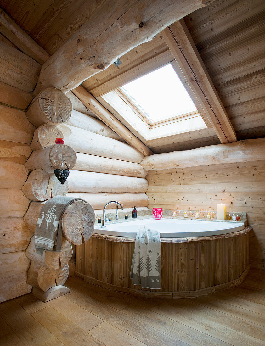 Corner bathtub below skylight in log cabin