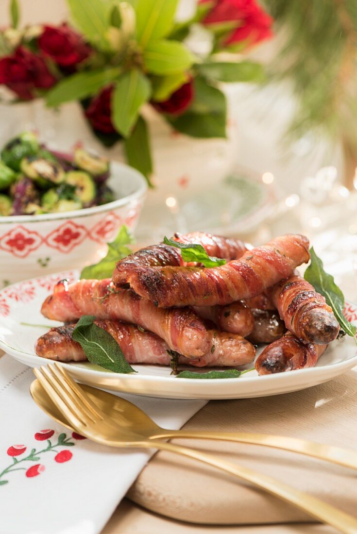 Chipolatas wrapped in bacon with ginger syrup for Christmas dinner