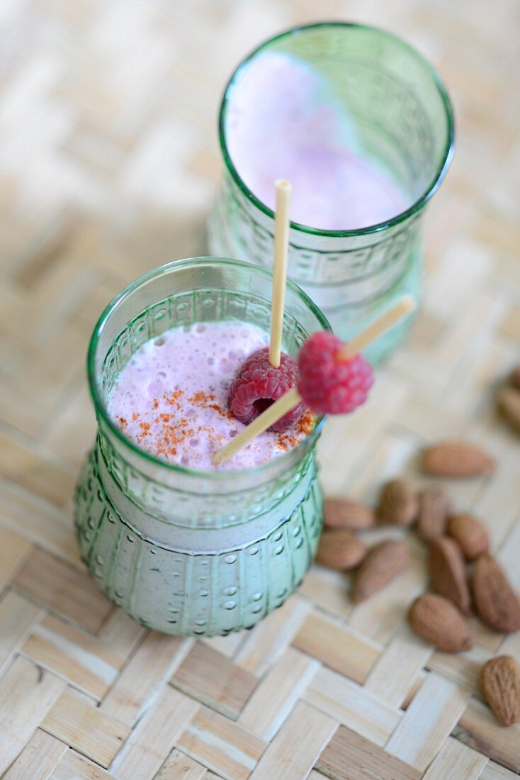 A smoothie with almond milk and raspberries