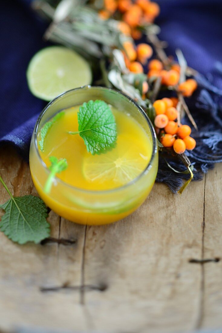 Sea buckthorn juice with slices of lime and lemon balm