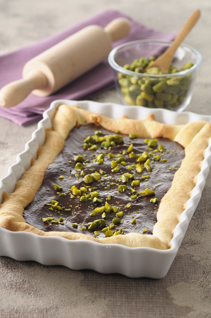 Chocolate tart with pistachios in a square-shaped baking dish
