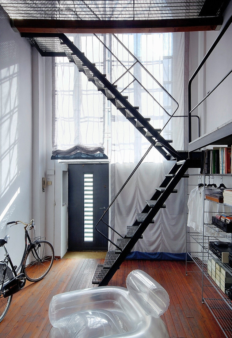 Metalltreppe zur eingezogenen Etage im schmalen, hohen Raum