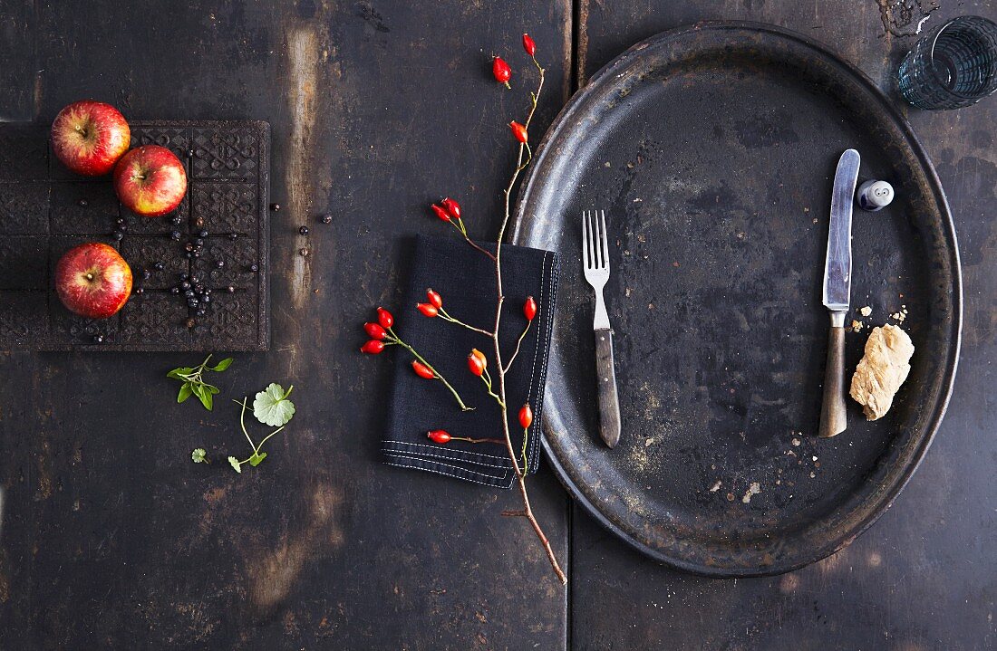 Apples and a rosehip branch on a vintage background