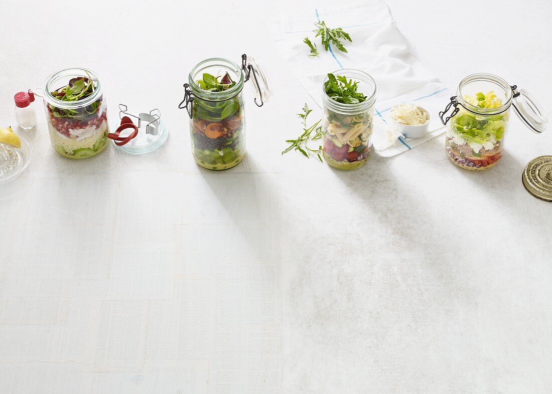 Vier verschiedene Salate im Glas