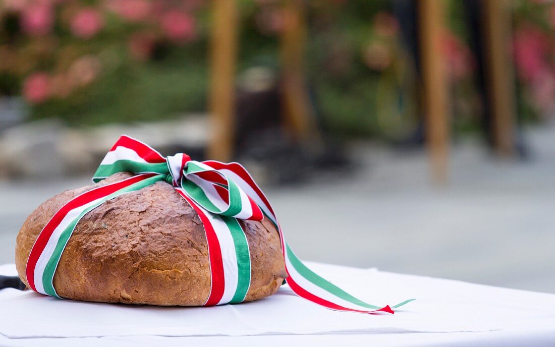 A loaf of bread wrapped with red, white and green ribbon