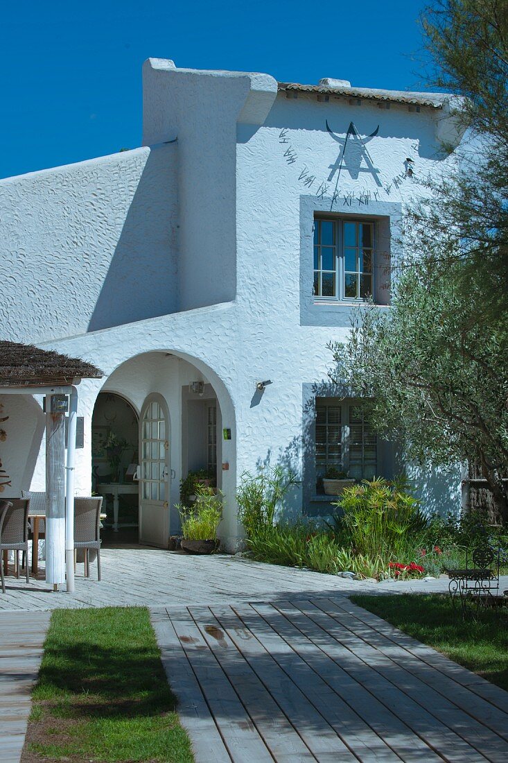 Terrasse und Weg mit Holzplanken zum mediterranen Haus