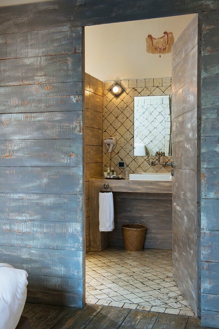 Mediterranean bathroom behind rustic board wall