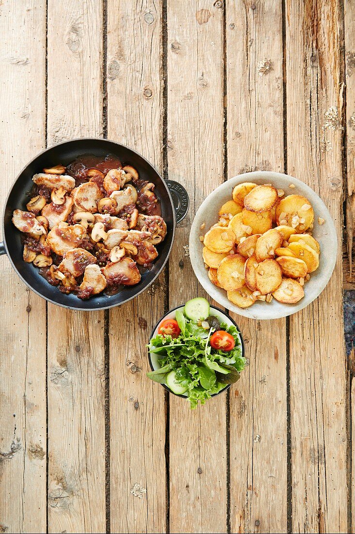 Pork chops with fried potatoes and lettuce