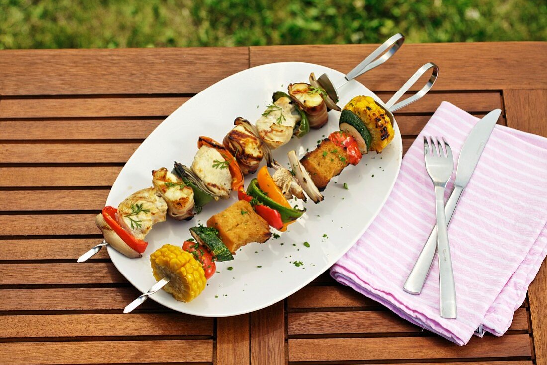 A vegetable skewer with bread chunks, and a chicken skewer with grilled cheese