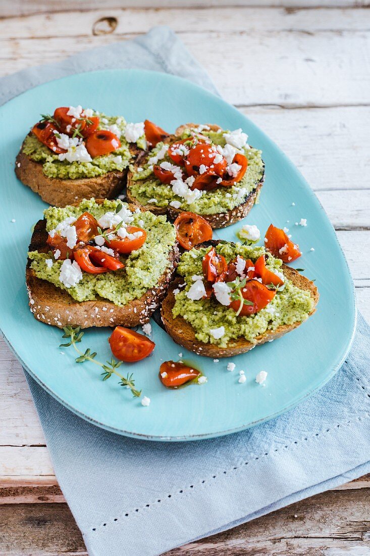 Bruschetta mit Zucchini-Pesto, geröstete Tomaten, Feta-Käse und Thymian