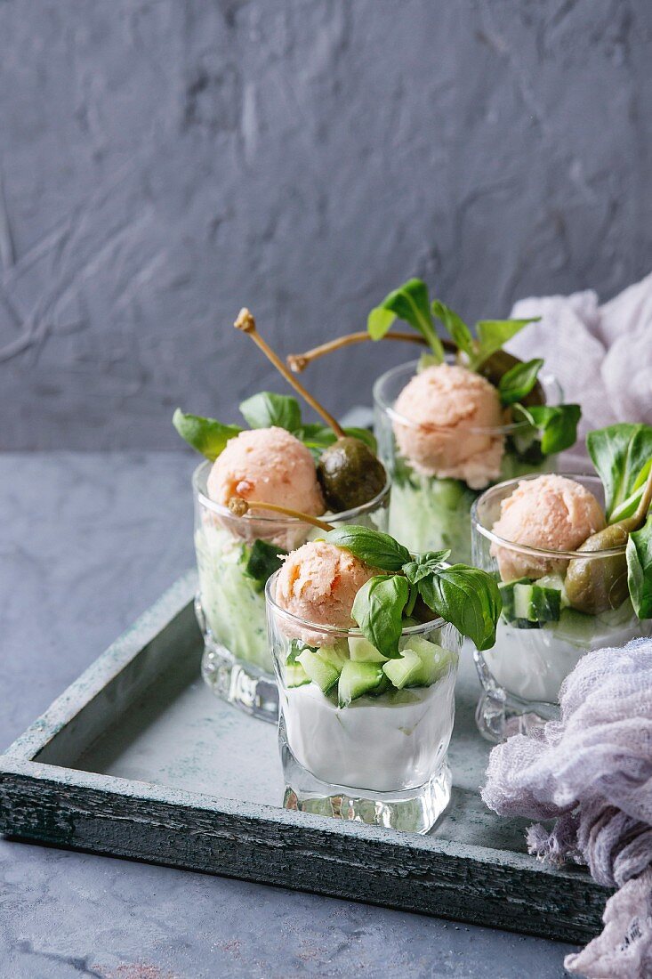 Verrines appetizer with salmon pate, red caviar, cucumber, cream cheese, herbs, capers in glasses