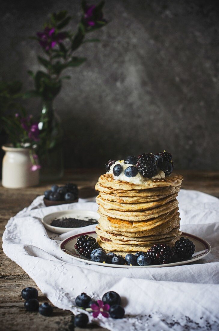 Ein Stapel Ricotta-Pancakes mit Beeren vor dunklem Hintergrund