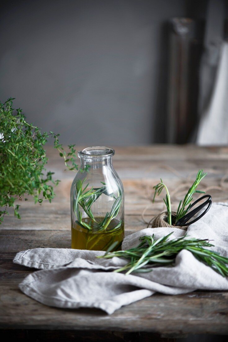 Rosemary infusion in a glass on a rustic wooden table