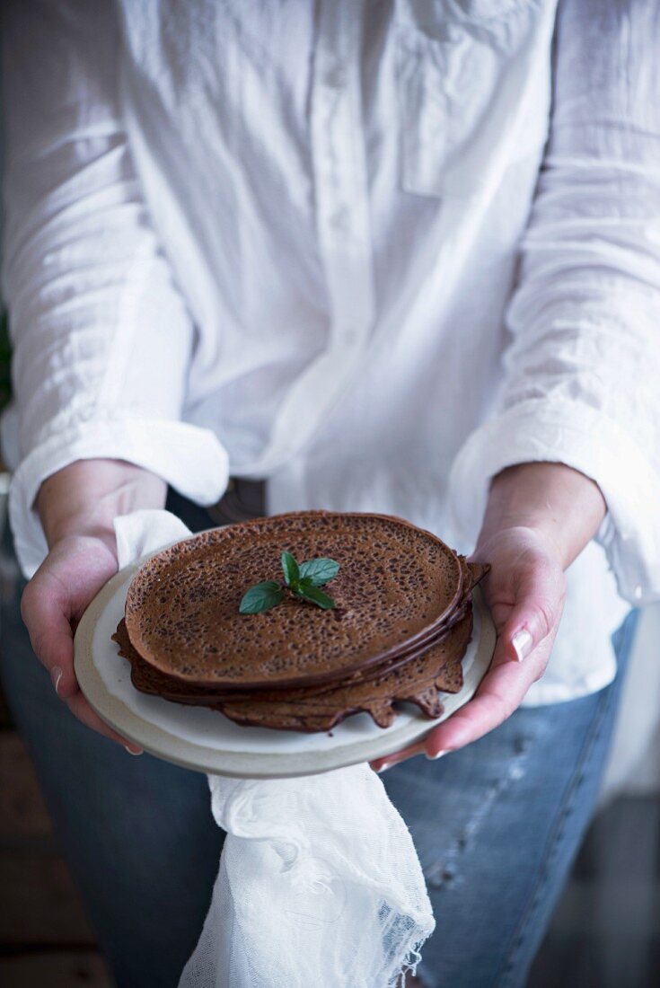 A woman serving chocolate pancakes