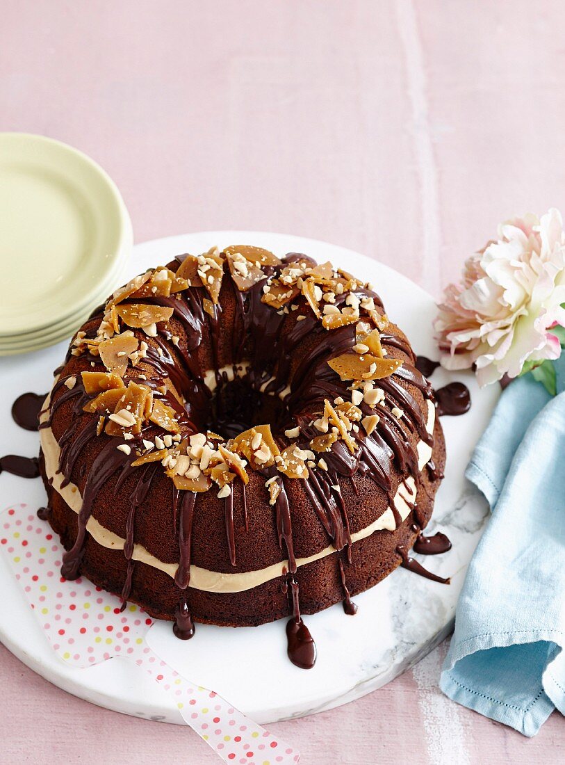 Schokoladenmarmorkuchen dekoriert mit Schokoglasur und Erdnusskaramell