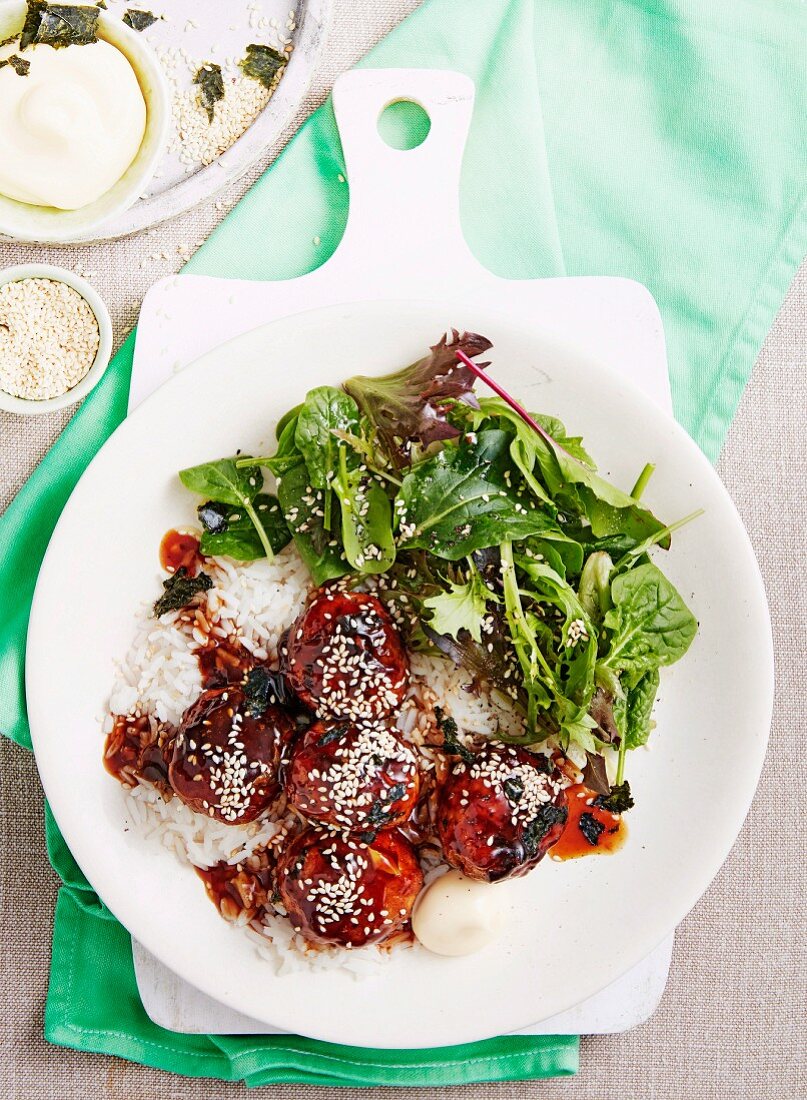 Glasierte Teriyaki-Fleischbällchen auf Reis mit gemischtem Blattsalat