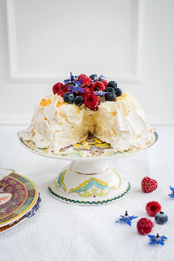 Pavlova mit frischen Beeren, angeschnitten