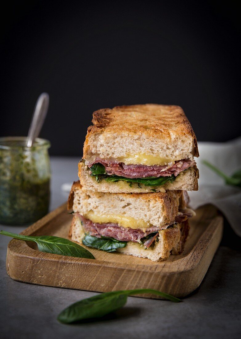 Grilled sandwiches with cheese, ham, pesto and spinach