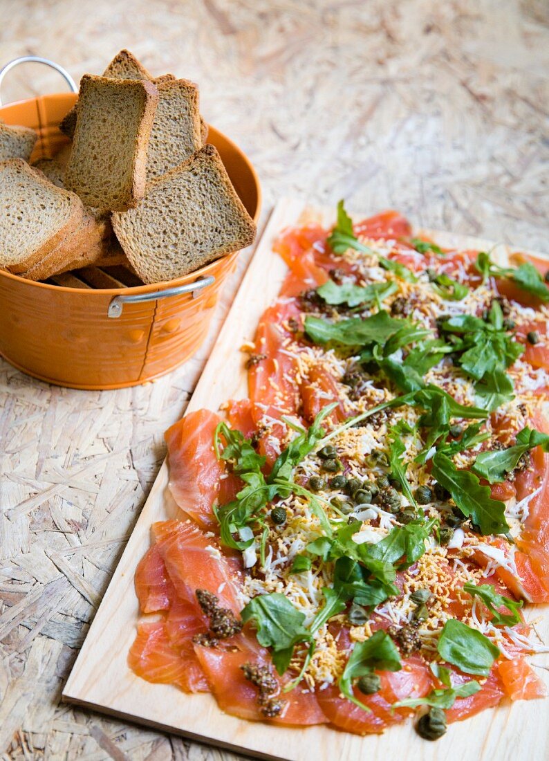 Marinated salmon with capers, cheese and arugula