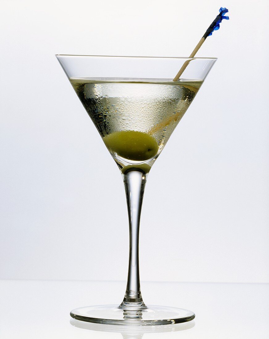 Martini dry mit Wodka im Aperitifglas mit Olive am Spieß