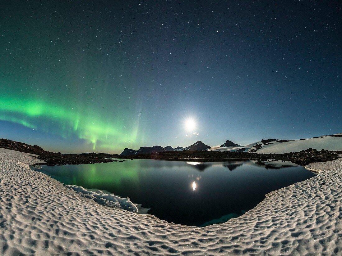 Moon and aurora borealis over a lake