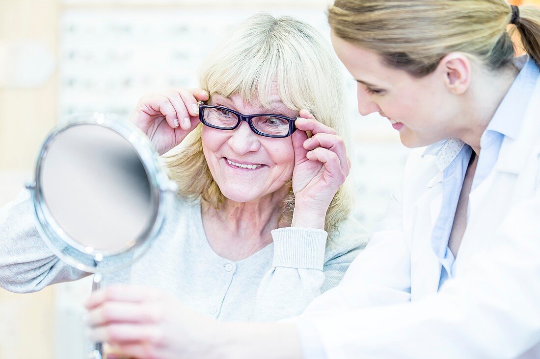 Optometrist helping senior woman