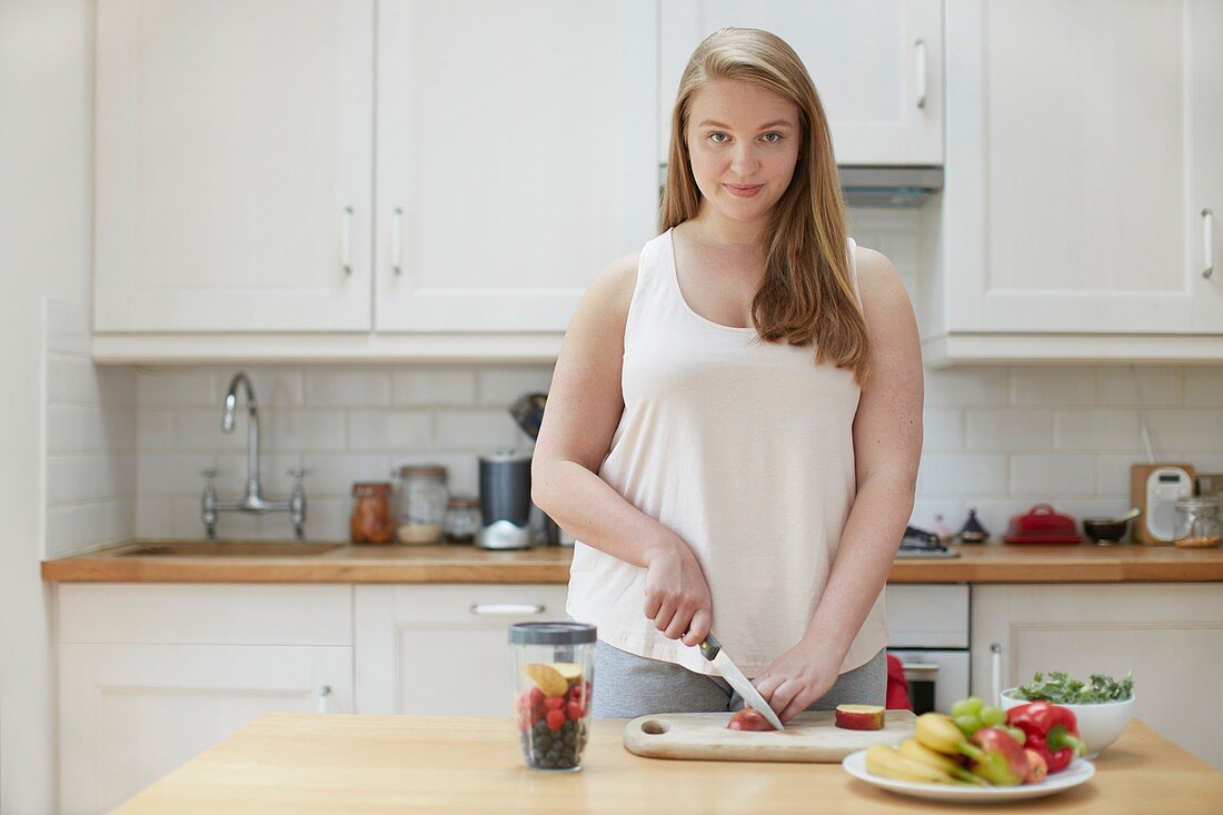 Young woman preparing healthy food in kitchen