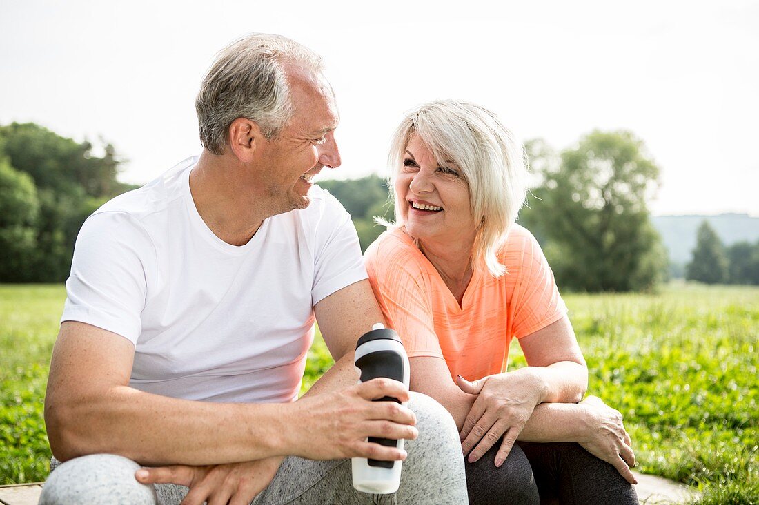 Mature couple sitting outdoors resting