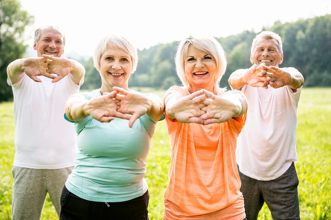 Four people exercising with arms outstretched
