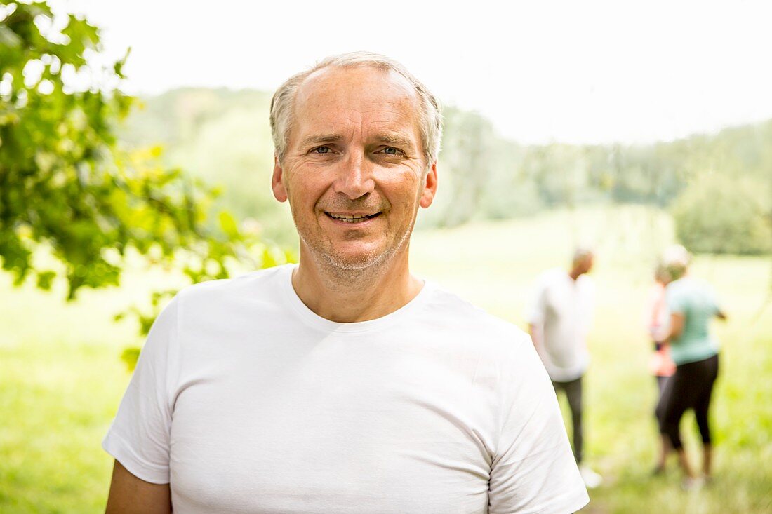 Mature man wearing white t-shirt smiling towards camera