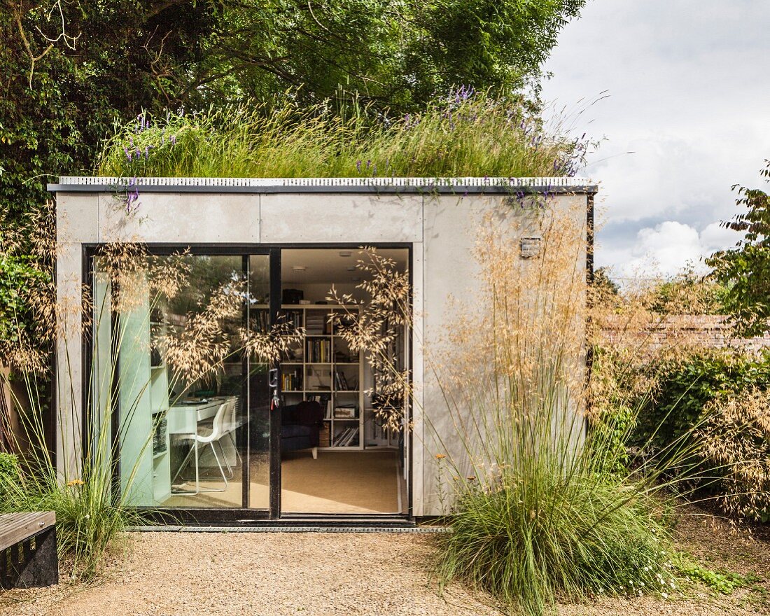 Cubist bungalow with glass living room wall in garden