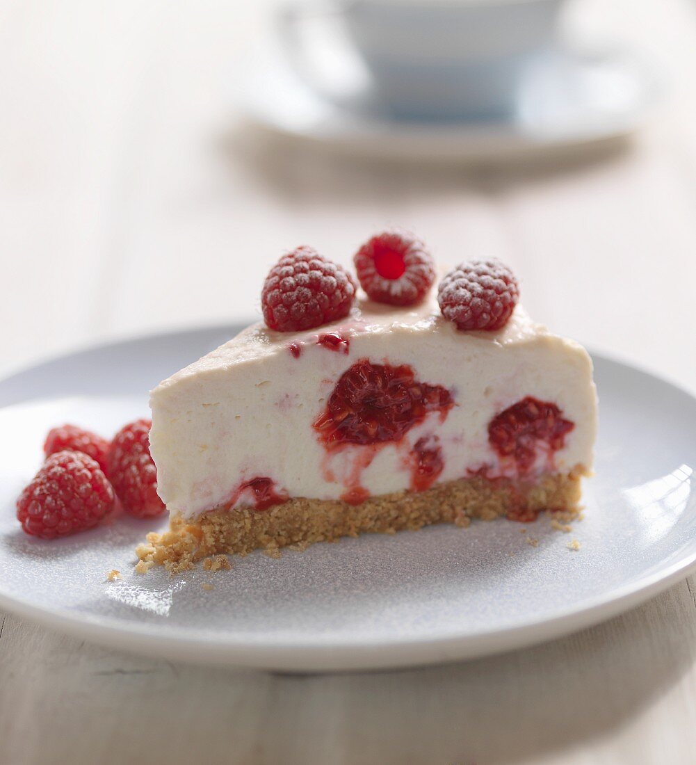 A slice of cheesecake with raspberries