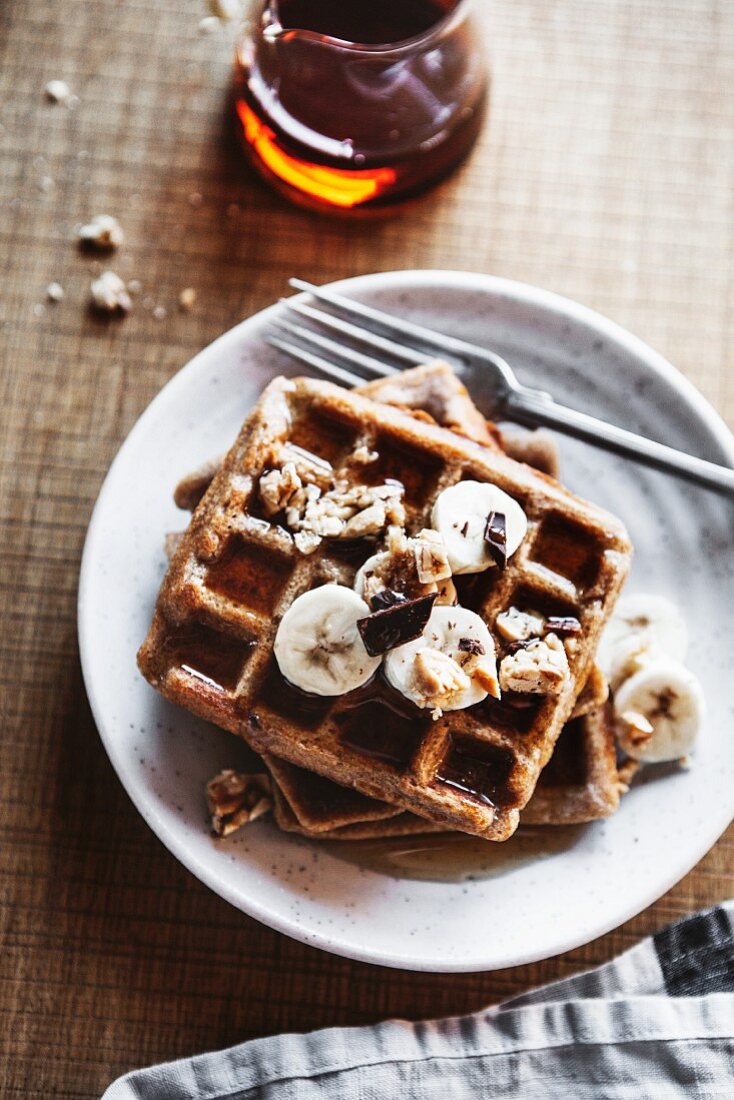 Wholemeal waffles with bananas, peanut butter, and syrup