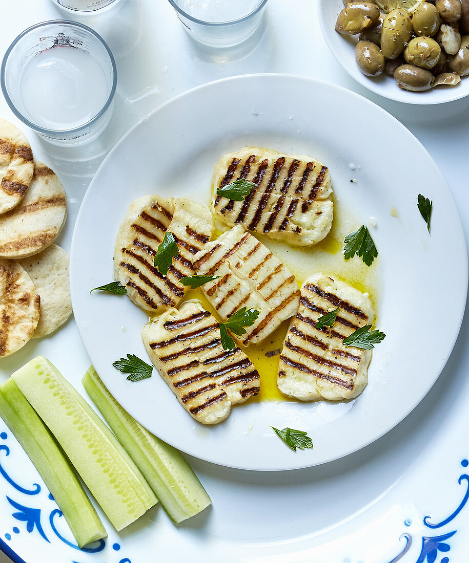 Sliced grilled halloumi with ouzo, olives, bread and gherkins (Cyprus)