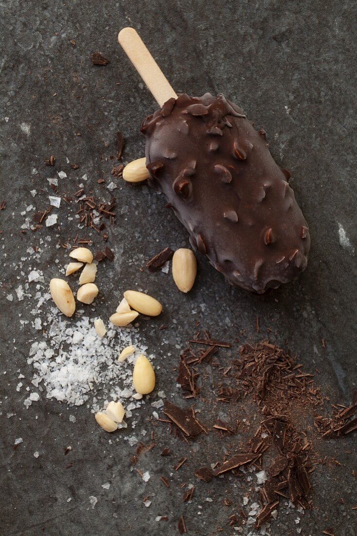 A chocolate and nut ice lolly with almonds, chocolate shavings and sea salt