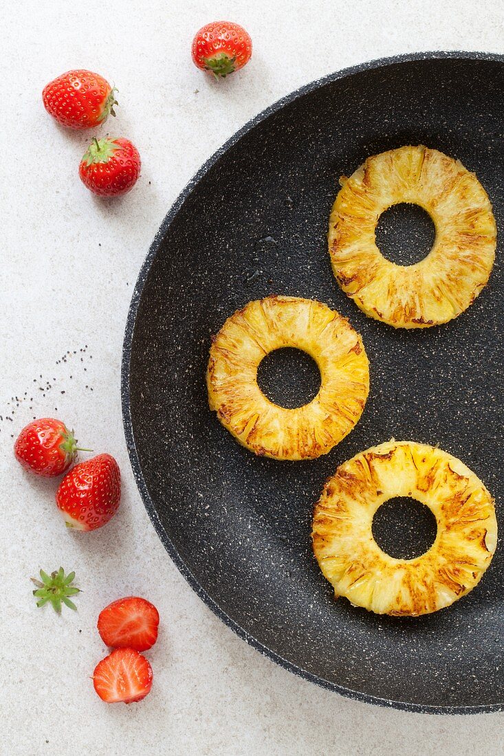 Griddled pineapple rings in a pan