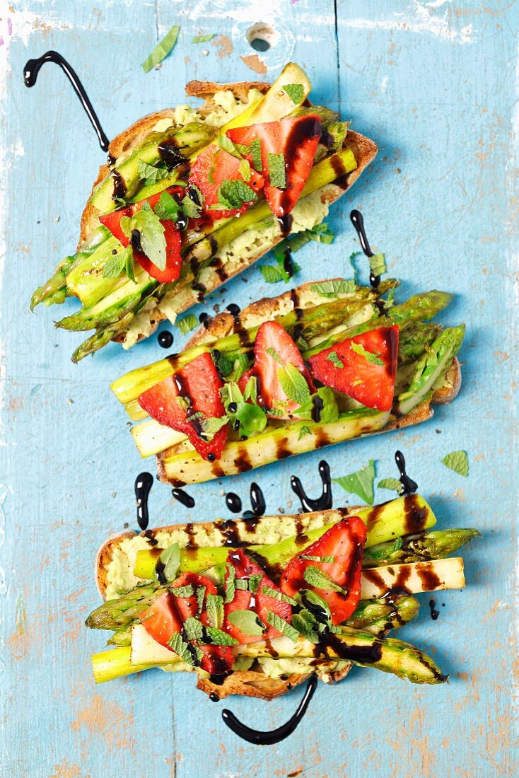 Bread with avocado spread, grilled asparagus, strawberries and balsamic glaze