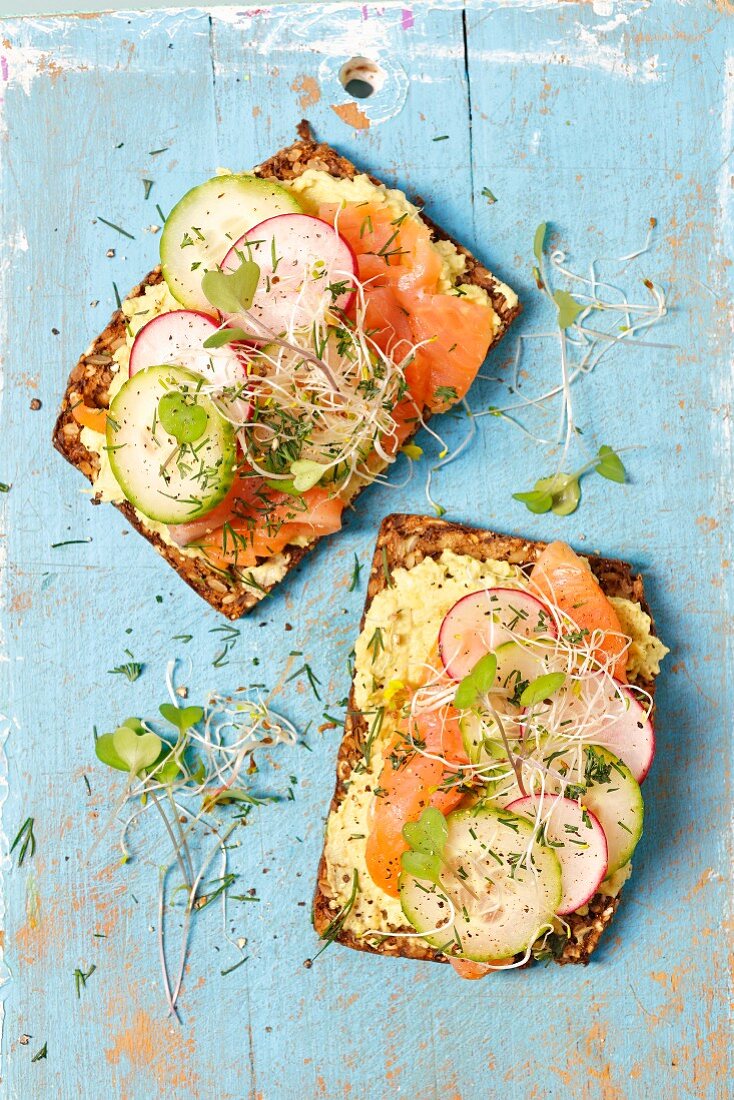 Wholemeal bread with avocado and cream cheese spread, smoked salmon and sprouts