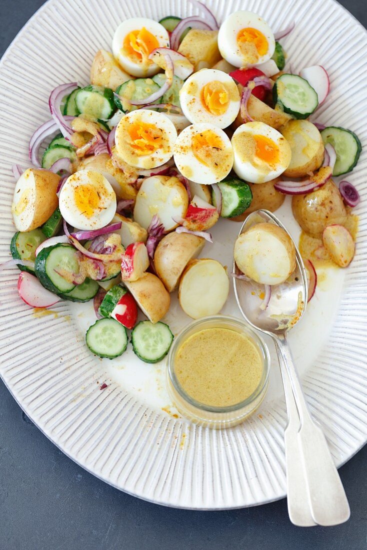 Kartoffelsalat mit Gurke, Radieschen, hartgekochten Eiern und Senfsauce