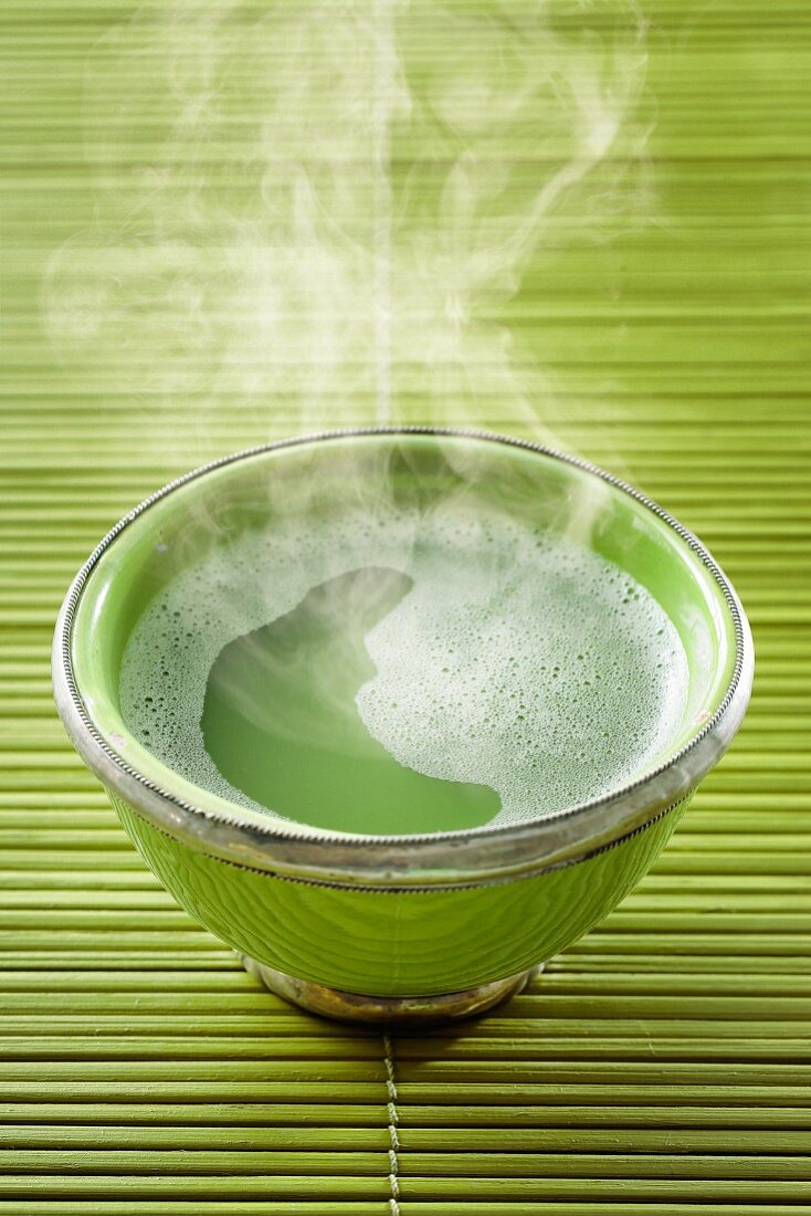 A steaming bowl of matcha tea