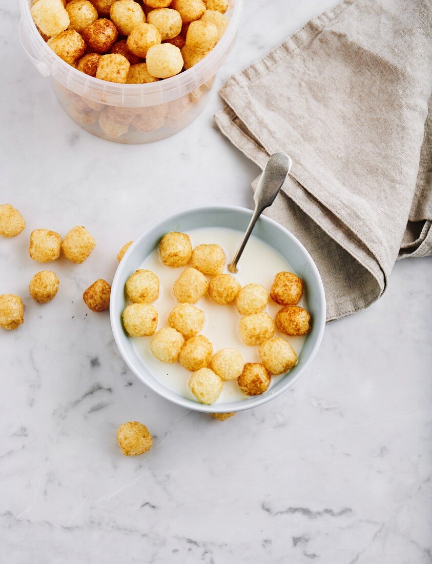 Corn pops in a plastic tub and in a bowl with milk