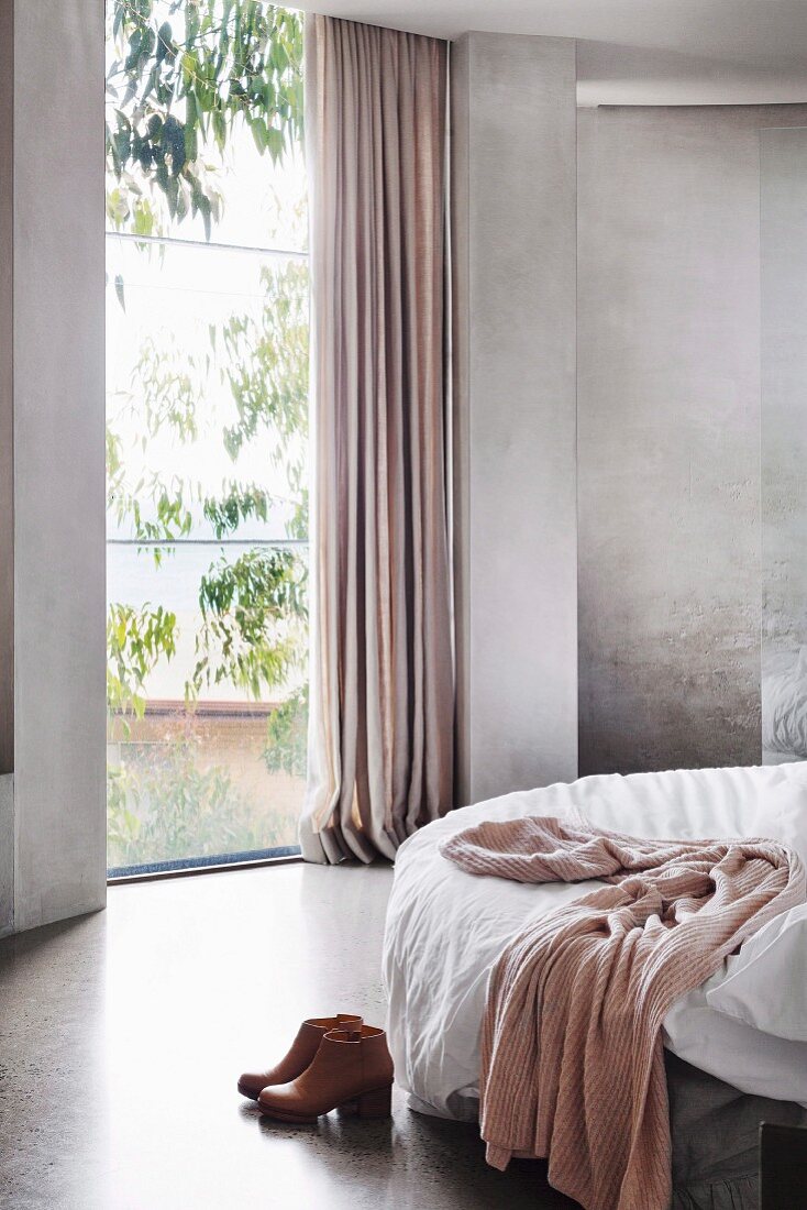 Bedroom in shades of gray with floor-to-ceiling window