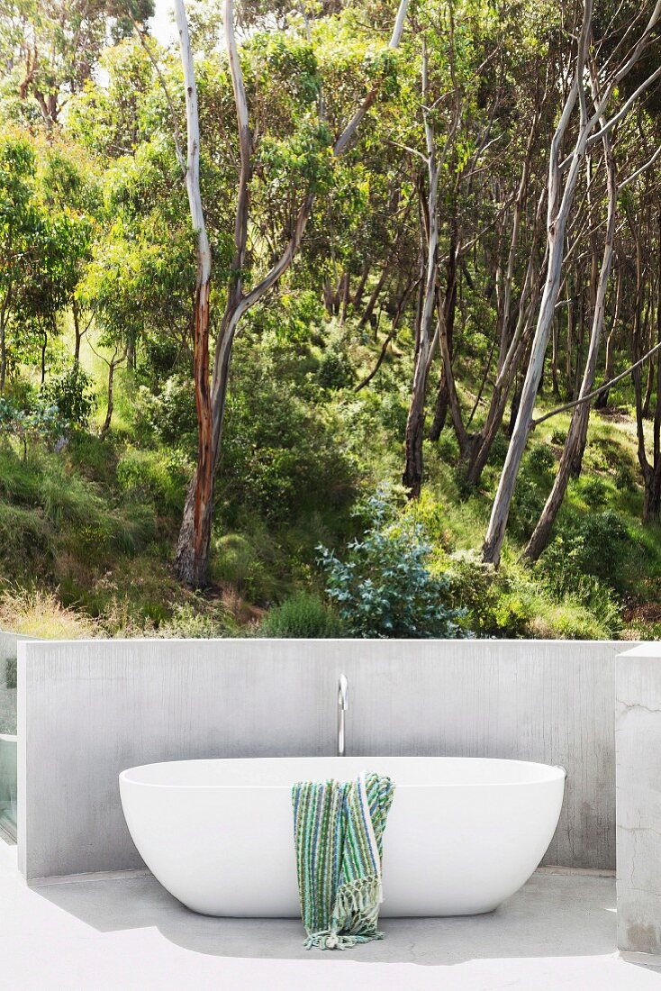 Modern outdoor bathtub with a view of the summer forest