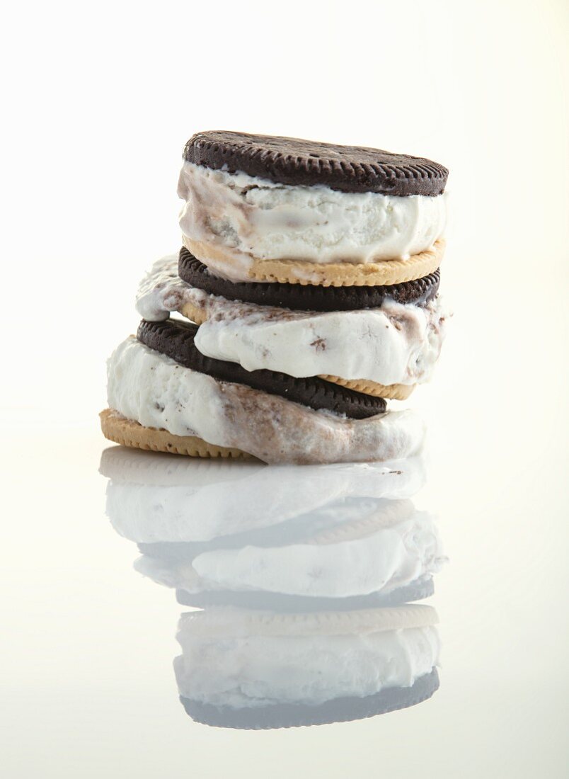 A stack of ice cream sandwiches melting and reflected on a shiny white surface