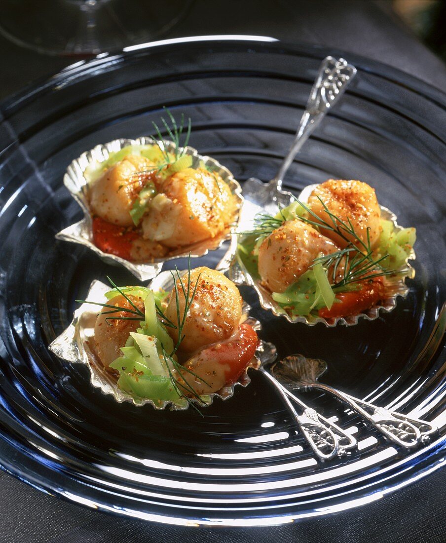 Scallops served with vegetables in silver mussel shells