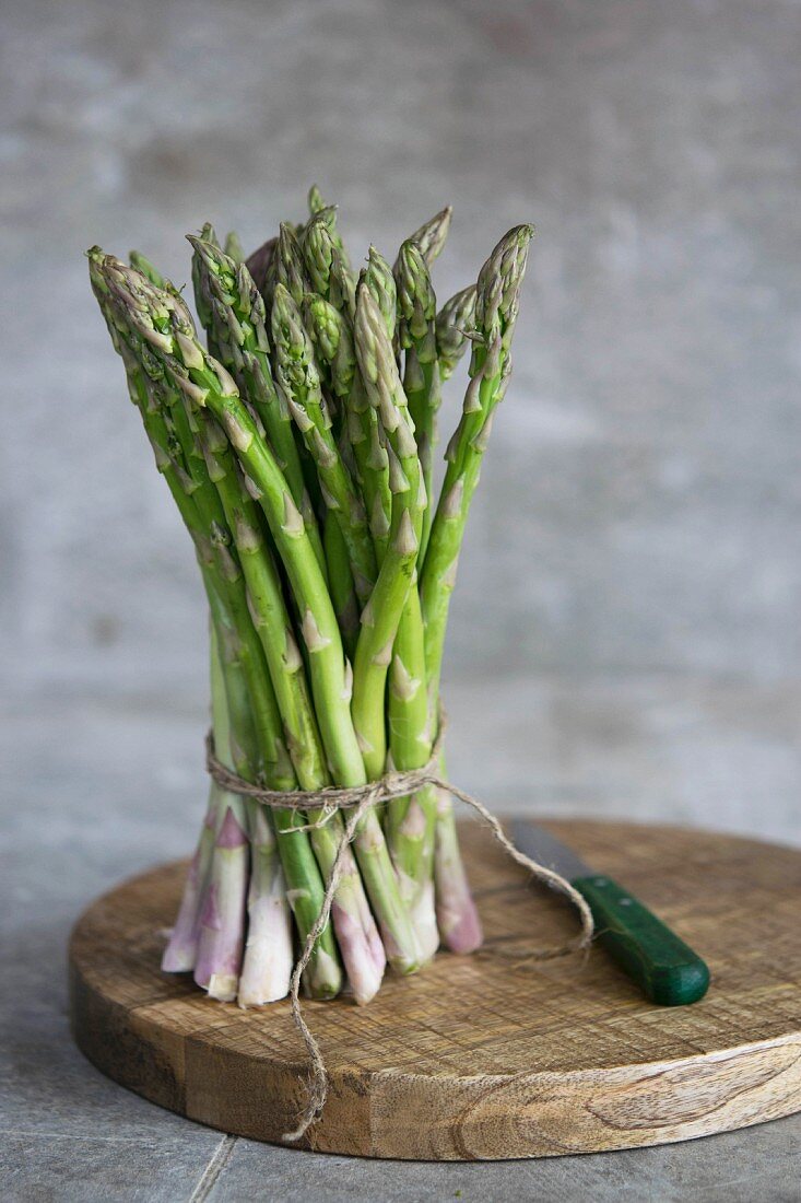 A bunch of fresh asparagus on a wooden board