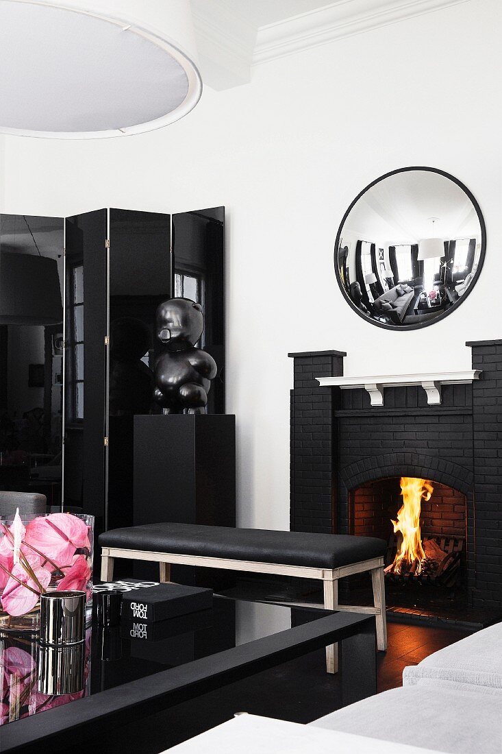 Elegantes, schwarz-weisses Wohnzimmer mit Kaminfeuer