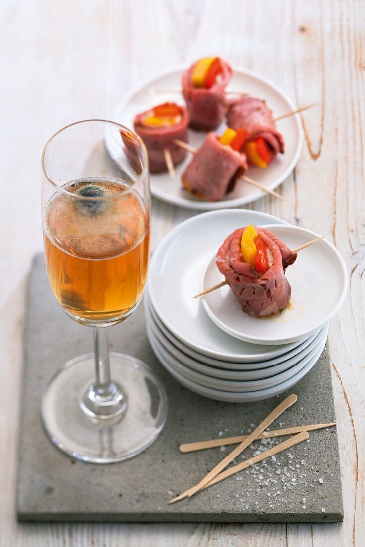 A Black Pearl cocktail served with roast beef tonnato with red and yellow pepper