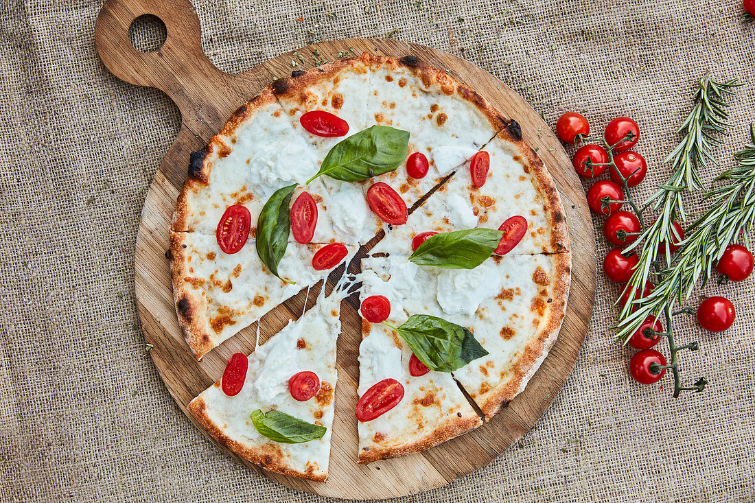 A pizza with buffalo mozzarella, cherry tomatoes and basil